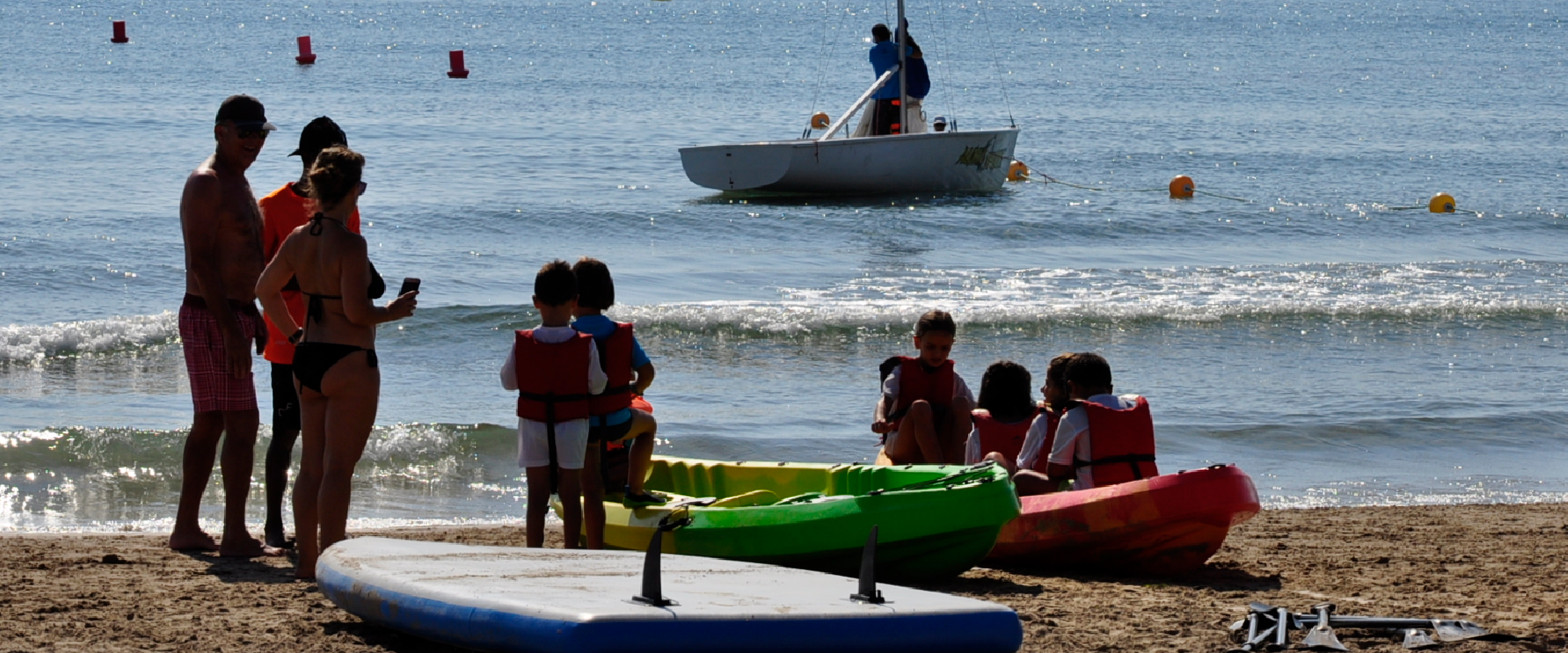 Foto de niños aprendiendo a realizar actividades náuticas en la playa de San Juan